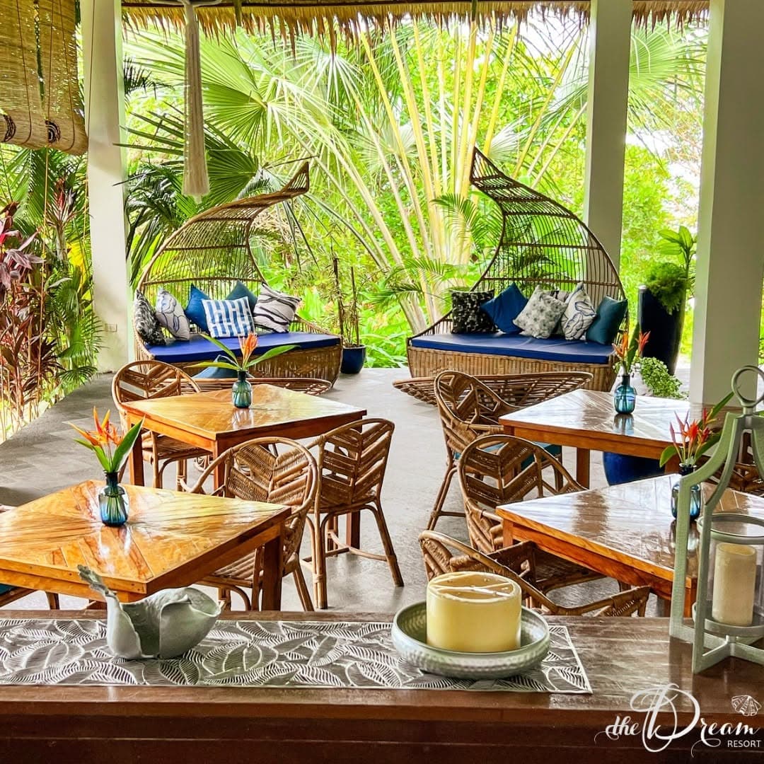 Open-air dining lounge with rattan furniture and blue cushions